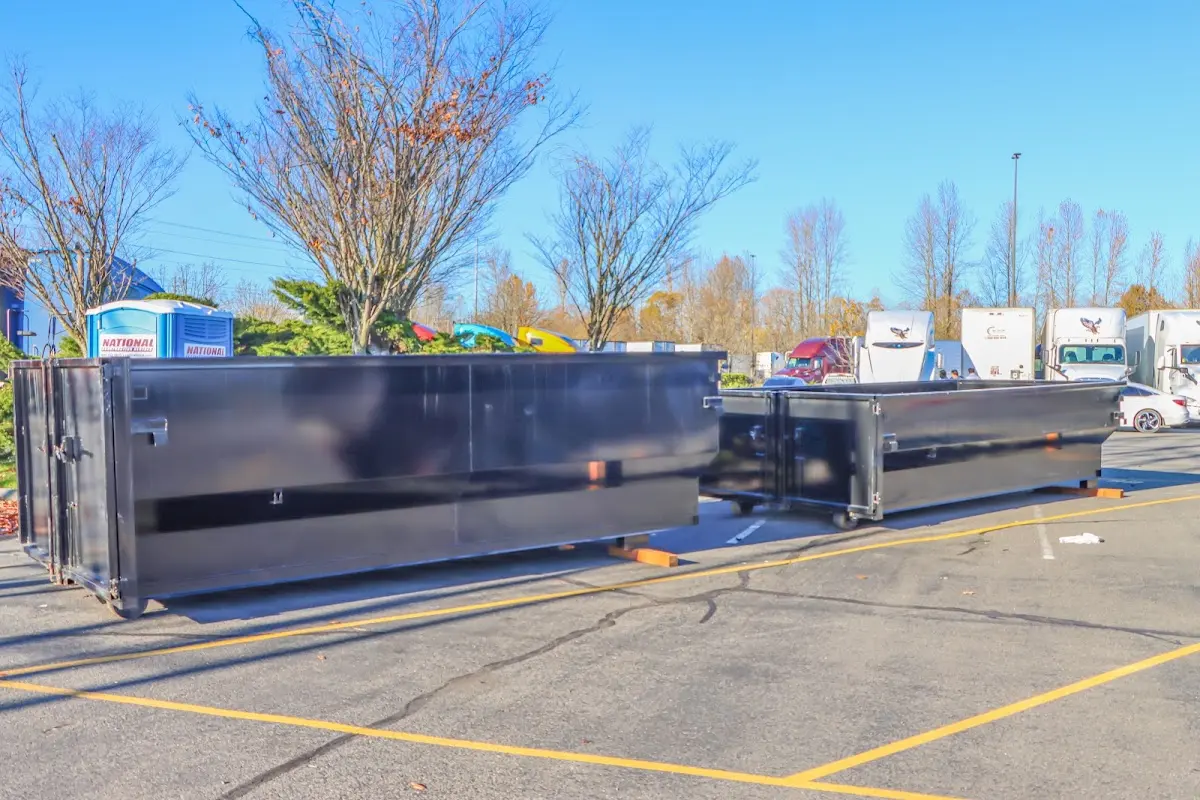 Professional dumpster rental service with roll-off container on residential driveway in Makaha